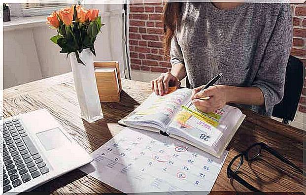 A woman who writes in the planner.