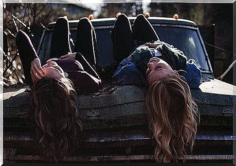 two good friends lying on an old car