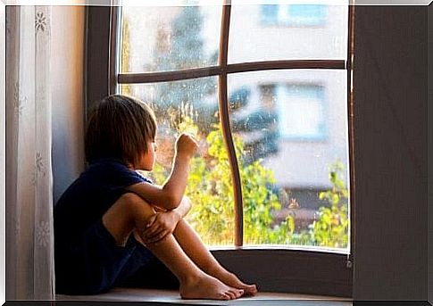 Little boy looks out the window