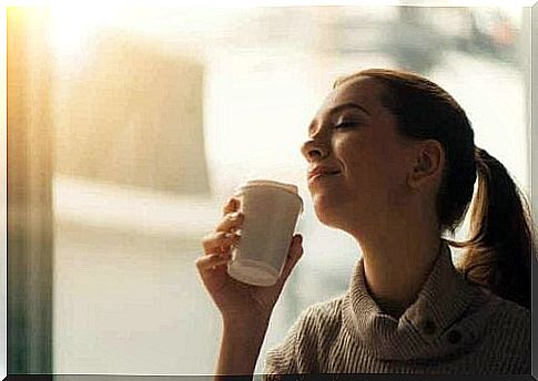 A woman sitting in a cafe drinking coffee.