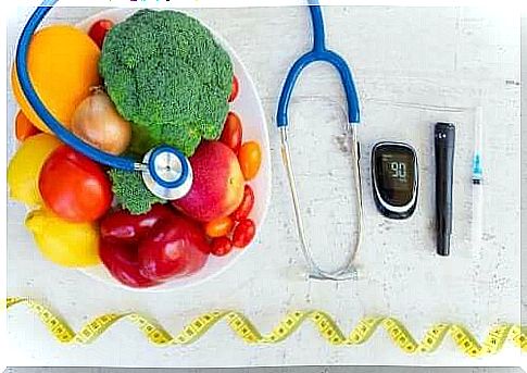 Diabetes care instruments next to a bowl of fruits and vegetables.