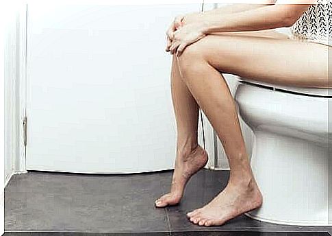 A woman sitting on the toilet.