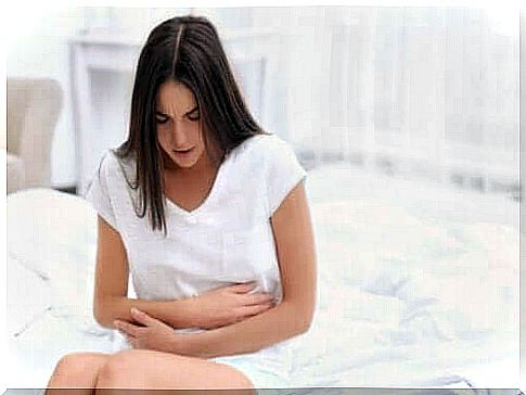 Woman with abdominal pain in white room