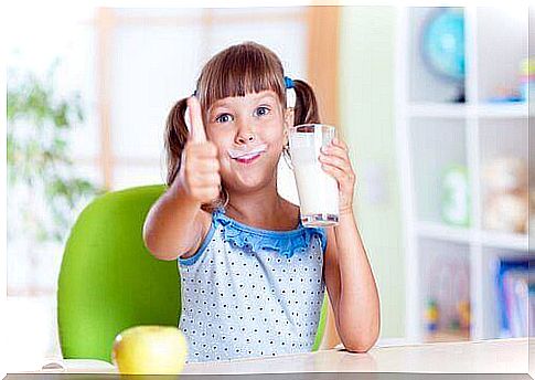 A girl drinking a glass of milk.