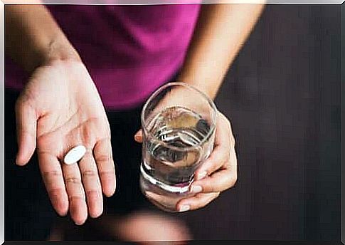 Woman taking paracetamol with water.