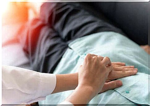 Colon cancer patient lying on the couch with the doctor's hands on his torso