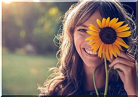 A happy woman and a sunflower.